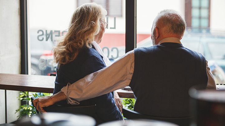 older couple sitting at table restaurant cafe