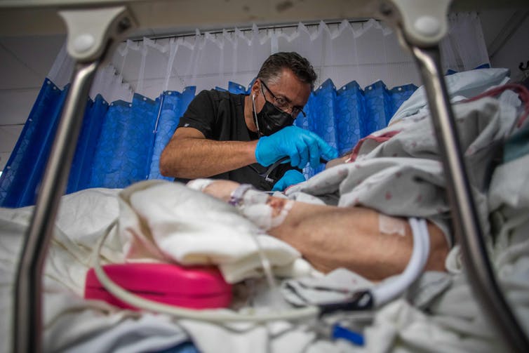 doctor checking on a COVID-19 patient in a hospital bed