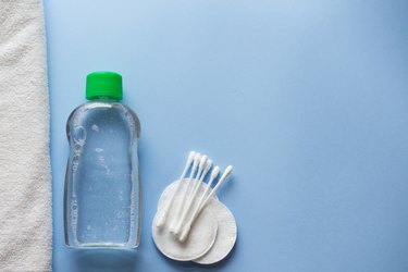 cotton pads, bottle with tonic or micellar cleansing water on blue background, top view. Beauty, skin, hair or body care concept.selective focus. flat lay. copy space