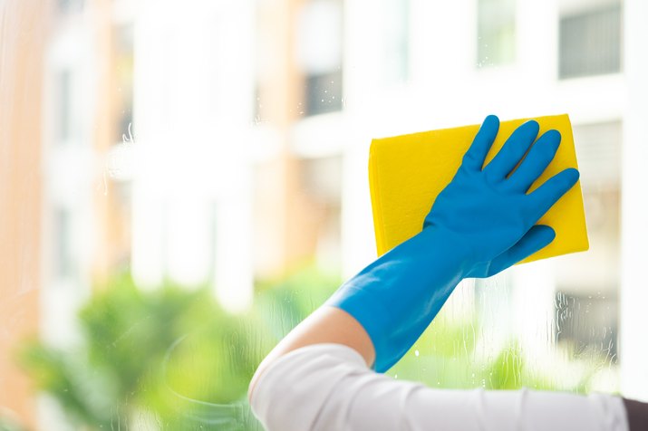 Cropped Hand Of Woman Cleaning Window Glass