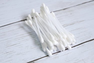 High Angle View Of Cotton Swabs On Wooden Table