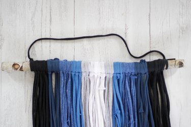 Grab some old t-shirts hanging around in your closet to create an eye-catching and stylish wall hanging.