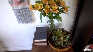 A vase of real flowers next to an arrangement of faux succulents.