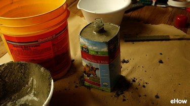 Molding concrete for DIY concrete tabletop tiki torches out of used glass bottles.