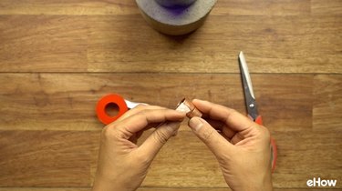 Copper coupling and nylon tape to use as wick holder for DIY concrete tabletop tiki torches out of used glass bottles.