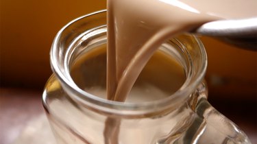 Pouring homemade sugar-free Irish cream liqueur into an airtight beverage container