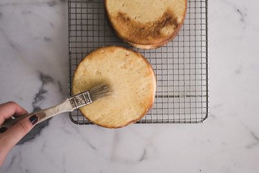 Glaze the cake layers in the syrup.