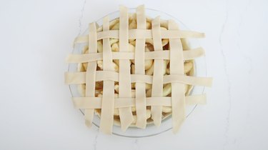 Strips of dough woven into lattice pattern on pie