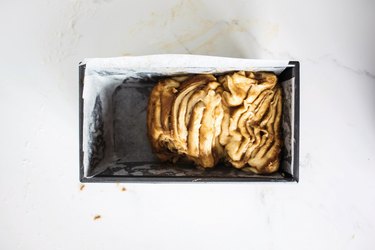 Dough slices in a prepared loaf pan.