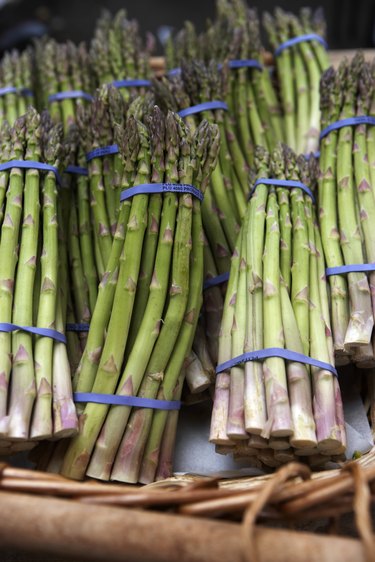 Basket of asparagus on market stall, close-up